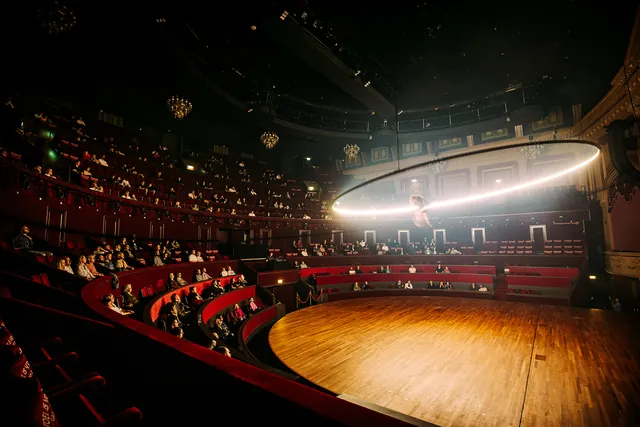 Orbiter ring light suspended above a theatre stage during a performance (photo: Nathan Reinds)